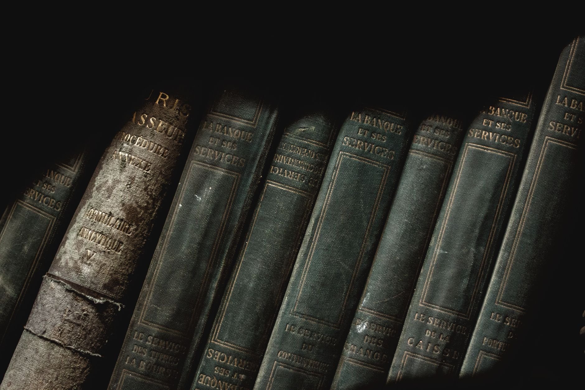 A shadowed view of vintage French leather-bound books showcasing a classic library vibe.